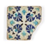 A Damascus Iznik tile fragment, 17th century, formerly of square form, the white ground decorated in