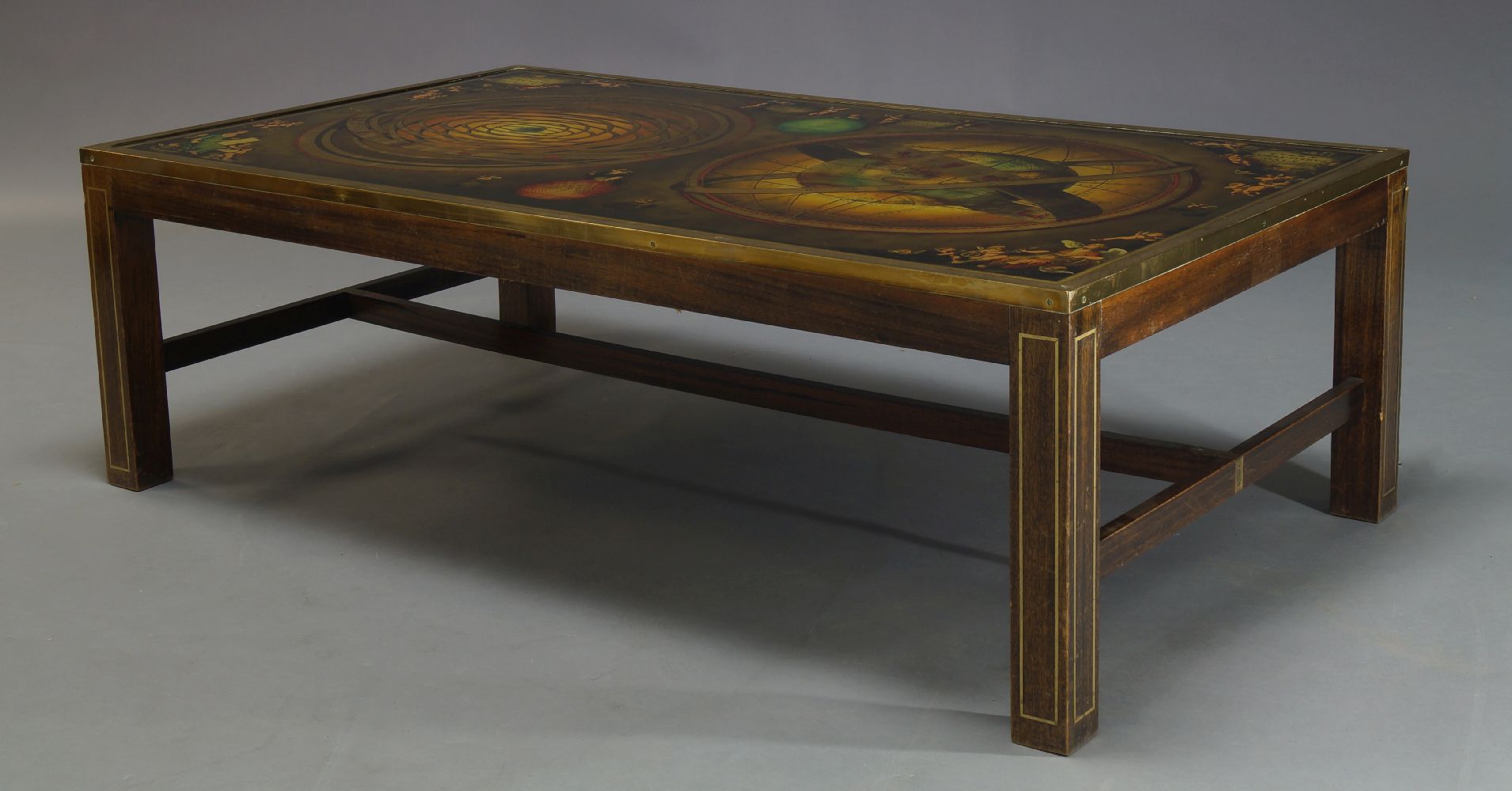 A large reverse printed glass and brass bound coffee table, c.1960, the glass top decorated with