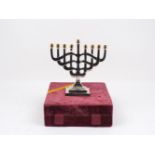 A modern Fred Hollings Jewish menorah, of typical form, with stylised overlapping branch design,