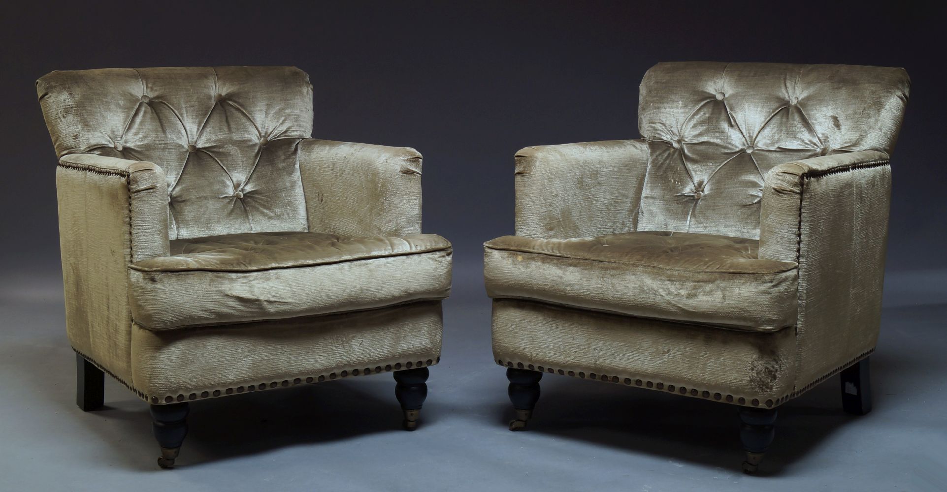 A pair of button back armchairs, of recent manufacture, upholstered in green velvet fabric, with