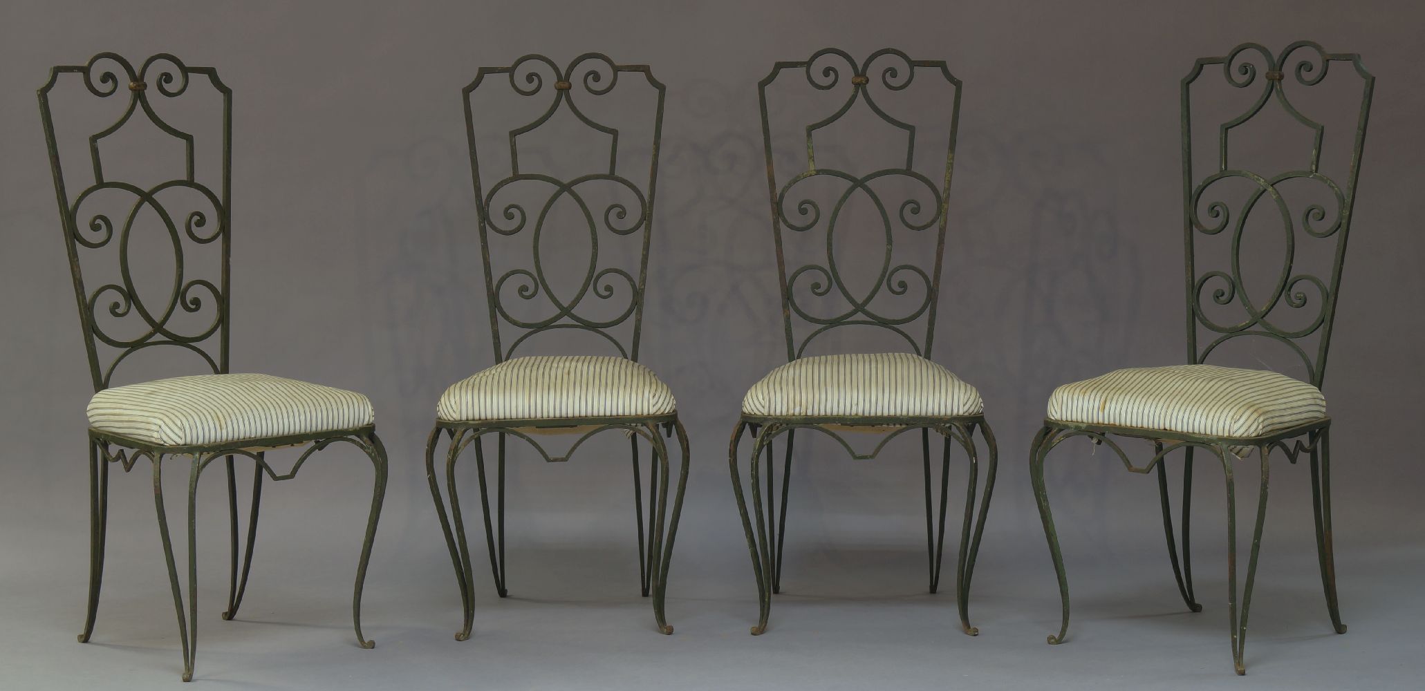 A set of four wrought iron and green painted chairs in the manner of Jean Charles Moreux, 20th