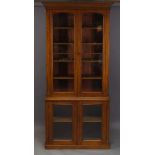 A Victorian mahogany bookcase, the moulded cornice above glazed doors enclosing four shelves, the