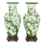 A pair of Chinese Peking green-overlay glass vases, late 19th century, carved with flowering