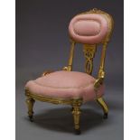 A Victorian gilt wood nursing chair, the oval backrest centred by carved ribbon, above pierced