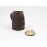 A Chinese carved wood mug, of typical cylindrical tapering form, decorated with relief of dragons,