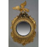 A Regency and later giltwood mirror, with carved eagle crest, the convex plate set within ebonised