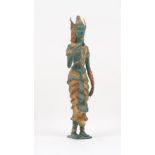 A Buddhist deity figure, 20th century, the patinated metal body modelled standing, holding a rose,