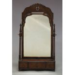 A Queen Anne walnut toilet mirror, the moulded frame with pierced fretwork top, on turned