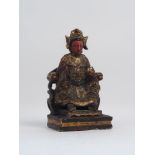 A Chinese carved figure, 20th century, decorated in a red palette, gilt highlights, modelled seated,