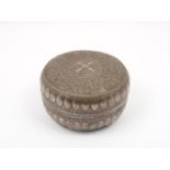 A late 19th / early 20th century Indian white metal betel nut jar and cover, of flattened circular