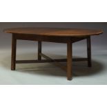 A George III style mahogany dining table, mid 20th Century, the oval top on square legs, united by