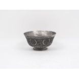 An Islamic style tin on copper bowl, of circular tapering form, designed with recurrent floral and