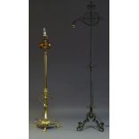 A wrought iron standard lamp, early 20th Century, the top with fleur de Lis and scrolling metal work