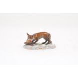 A Meissen figure of a fox with a chicken in its mouth, on scroll edged mound base, underglaze blue