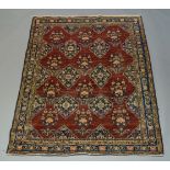 A Hamadan rug, with six lozenge medallions in a deep red field, 188cm x 155cmminor repairs to field,