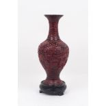 A Chinese cinnabar lacquer-style vase, 20th century, of baluster form, the red body decorated with