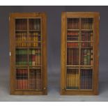 A pair of decorative hanging faux bookshelf cabinets, late 20th Century, the glazed oak cases,