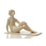 A Carved ivory figure c.1920, unsigned Carved as a naked woman sitting on the floor with her knees