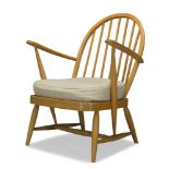 Ercol, a beech armchair c.1970 With hooped spindle back and out swept arms above seat with loose