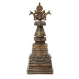 A Tibetan copper alloy stupa, 12th/13th century, the bell-formed base rising from a lotus motif band