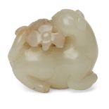 A Chinese pale green jade cat, 19th century, carved as a recumbent cat with heard turned back