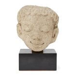 A Mon-Dvaravati Stucco Head of an Apsara, 8th/9th century, the smiling face with downcast eyes and a