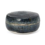A Chinese blue-glazed pottery cosmetic box, Tang dynasty, of circular form, covered in a slightly