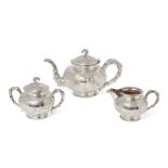 A Chinese silver three piece tea set, Tuck Chang & Co., repousse decorated with bamboo sprays on a