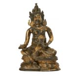 A Tibetan gilt bronze figure of Vaishravana, 18th/19th century, seated on a lotus throne wearing