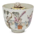 A Chinese porcelain tea bowl, Republic period, the exterior painted in famille rose enamels with