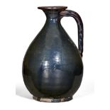 A Chinese stoneware black-glazed ewer, Yuan dynasty, the pear-shaped body with loop handle, narrow