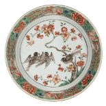 A Chinese porcelain plate, early 18th century, painted in famille verte enamels with birds amidst