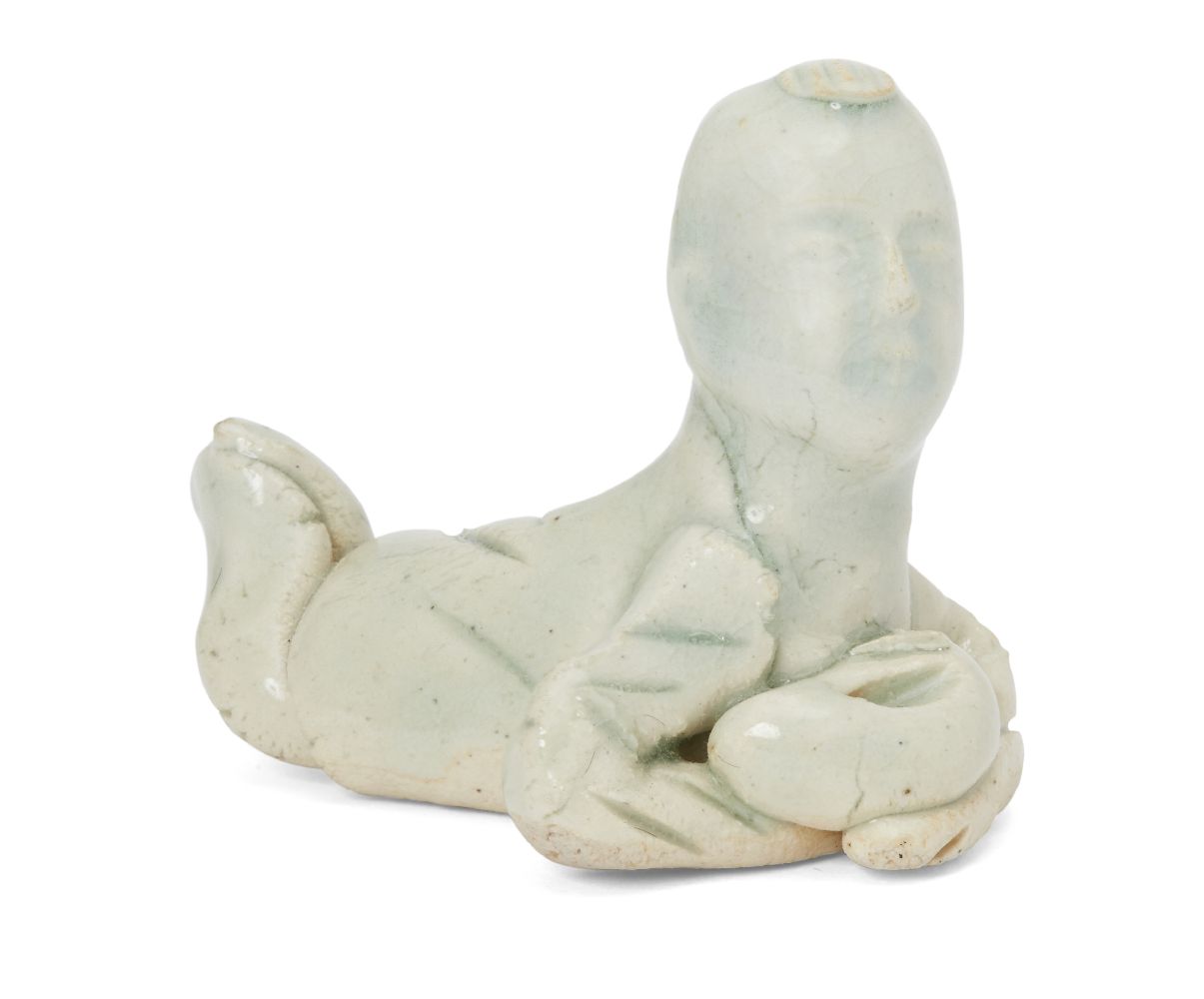 A Chinese porcelain qingbai brush rest, Song dynasty, modelled as a young child lying on its stomach