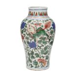 A Chinese porcelain wucai baluster vase, 17th century, painted with mythical beasts amongst