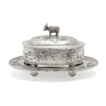 A Chinese silver oval butter dish and stand, Zee Sung, the cover with buffalo finial, repousse