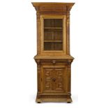 A late Victorian carved oak bookcase cabinet, the moulded cornice above gadrooned frieze, flanked by