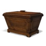 A William IV oak cellarette, of sarcophagus form, the hinged lid enclosing storage space, with