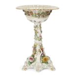 A large Meissen figural comport, 19th Century, the pierced basket encrusted with flowers on pink and