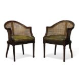 A pair of Regency style mahogany and caned bergere armchairs, early 20th century, the curved and