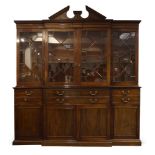A George III mahogany breakfront bookcase, the top surmount with broken pediment, over dentil