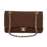 A Chanel clutch bag, the rectangular form brown fabric body designed with central white metal Chanel