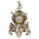 A Dresden porcelain figural mantle clock, late 19th century, the case encrusted with flowers and