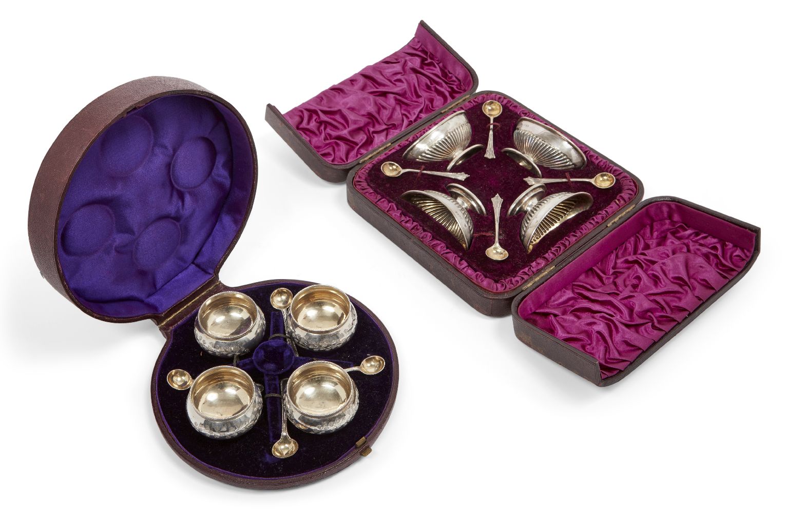 Two cased Victorian silver condiment sets, comprising a set of four rounded salt cellars, London,