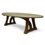 Peter Southall, a lime oak dining table, of recent manufacture, the oval top on curved laminated