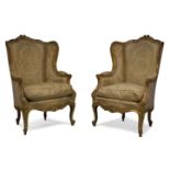 A pair of Louis XV style gilt and gesso wingback armchairs, early 20th century, the frames with