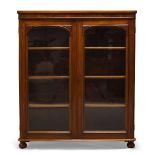 A Victorian mahogany bookcase, with two glazed cupboard doors enclosing three shelves, raised on bun