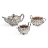 A three-piece tea set, comprising a George IV melon shaped teapot and milk jug, both stamped London,