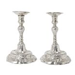 A pair of Continental silver candlesticks, marks rubbed, each raised on a stepped, scalloped foot