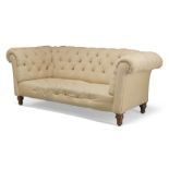 A Victorian button back Chesterfield sofa, upholstered in cream fabric, raised on turned mahogany