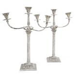 A pair of silver plated three branch candelabra, the columnar stems with acanthus capitals to